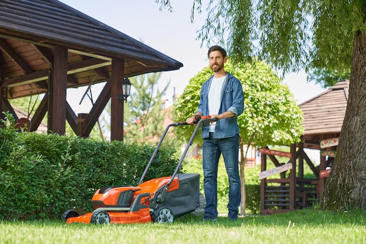 smiling-male-landscaper-denim-shirt-trimming-overgrown-lawn-with-lawn-mover-summer-day-low_7502-10170 (1)